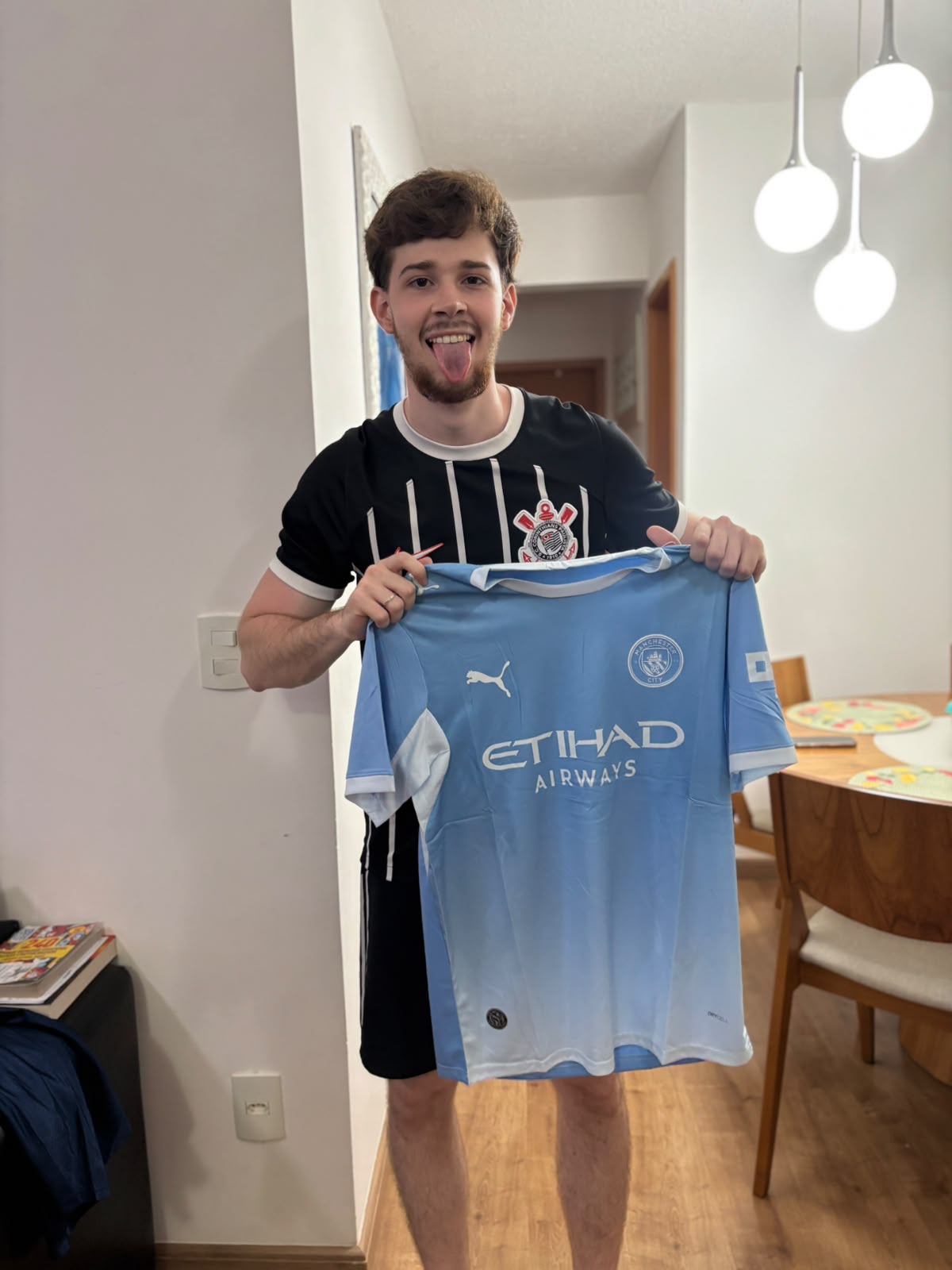 Cliente segurando a camisa do Manchester City recebida na Futbox